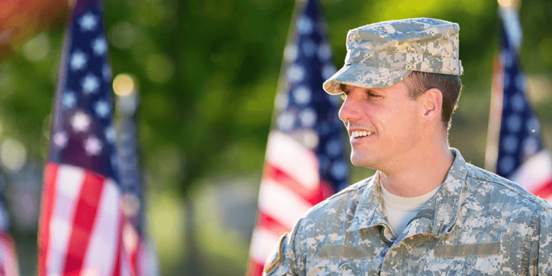 Military man in front of American flag