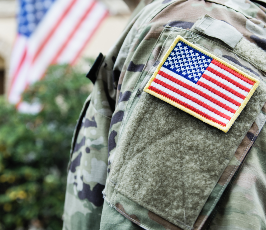 An armed forces soldier's shoulder showing a USA flag patch