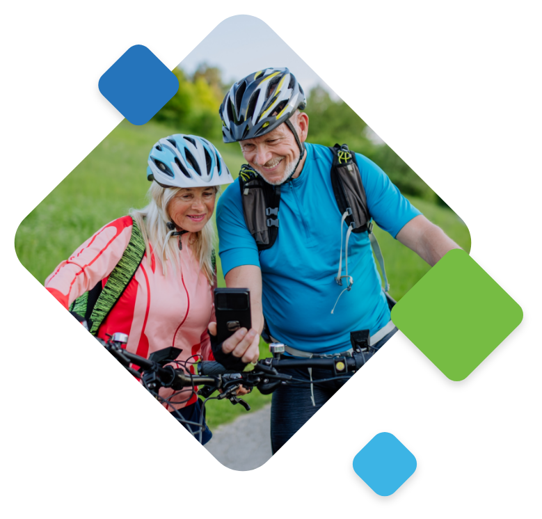 Senior cyclists enjoying a scenic ride together, sharing a smartphone moment