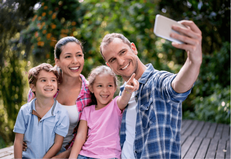 Family taking a selfie with two elementary aged kids