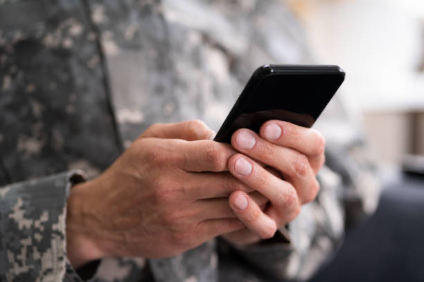 Image of serviceman with smart phone in hand.